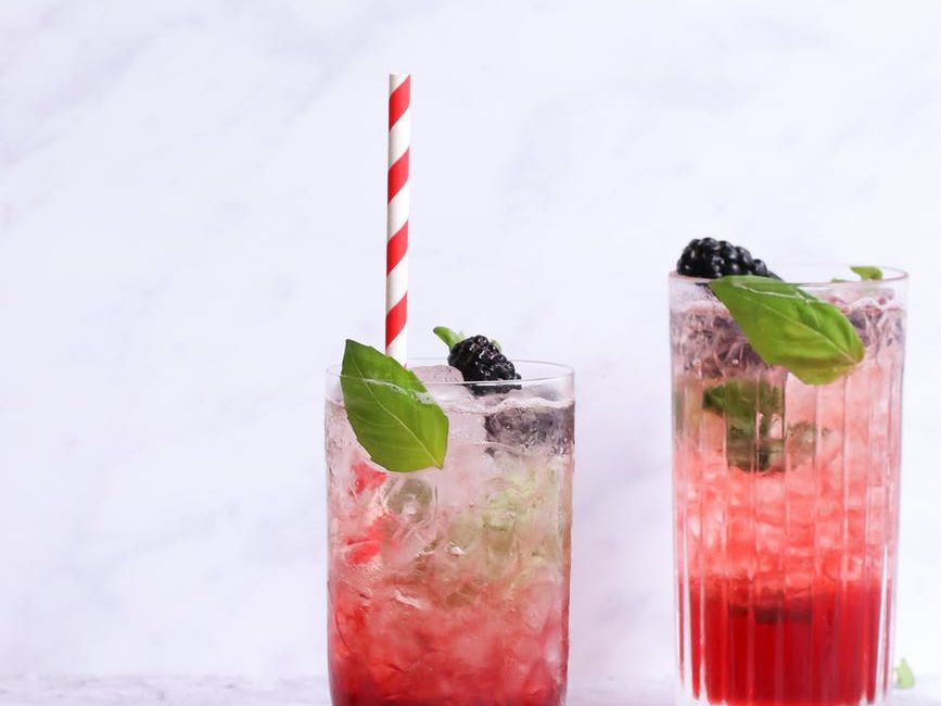 glasses of tasty beverages with blackberries and mint leaves