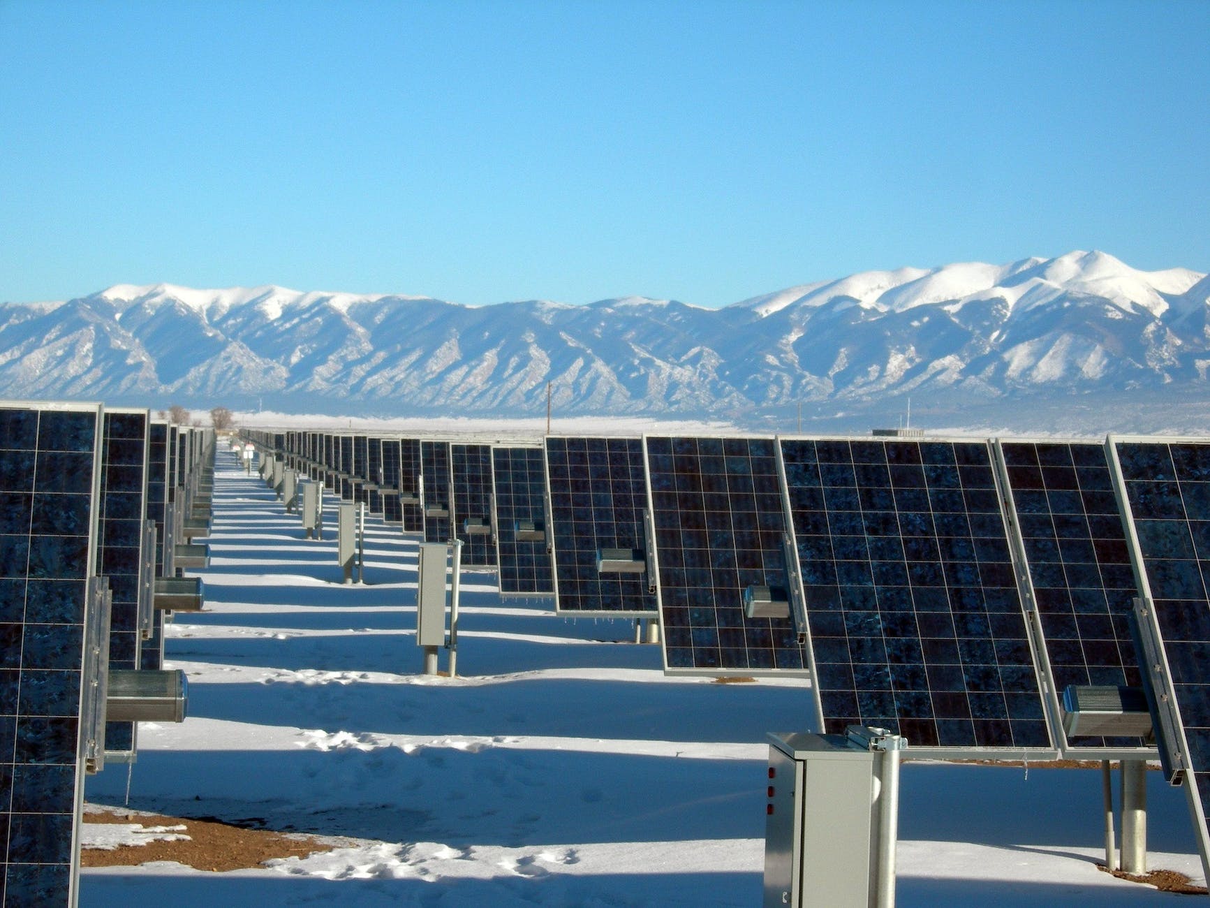 silver and black solar panels on snow covered ground